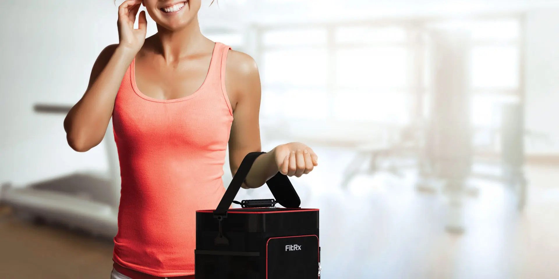 A woman using the Meal Prep Carry-All Cooler’s easy-carry handle to effortlessly take the cooler with her as she leaves the gym.