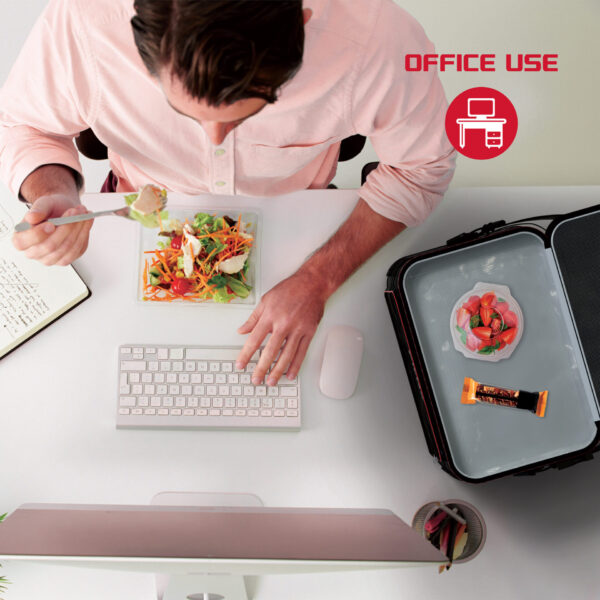 An office worker enjoying his lunch from the cooler right at his desk, thanks to the cooler’s hot and cold storage compartments.